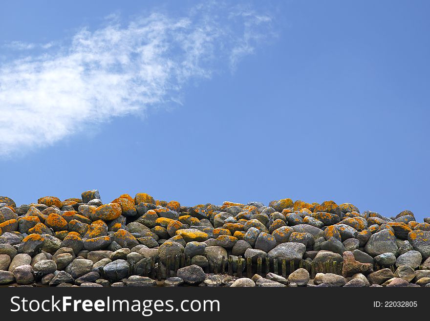 A heap of natural mossy stones against blue sky. A heap of natural mossy stones against blue sky