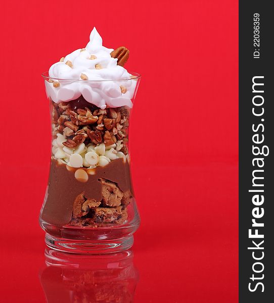 Chocolate with pecans and whipped cream on a red background. Chocolate with pecans and whipped cream on a red background