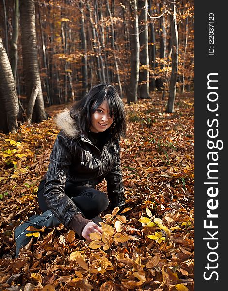 Young woman sitting on autumn leaves. Young woman sitting on autumn leaves