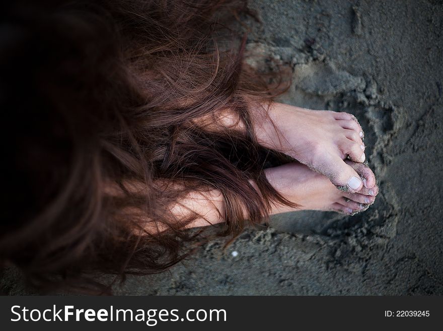Womans feet covered with her brown hair. Womans feet covered with her brown hair
