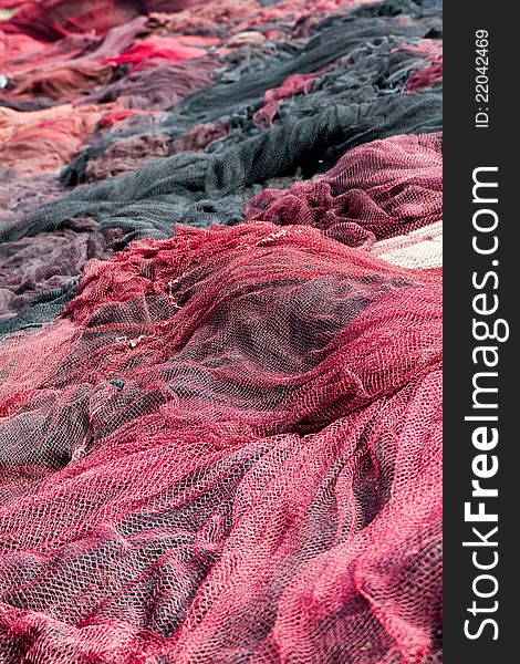 Red fishing nets drying on the port
