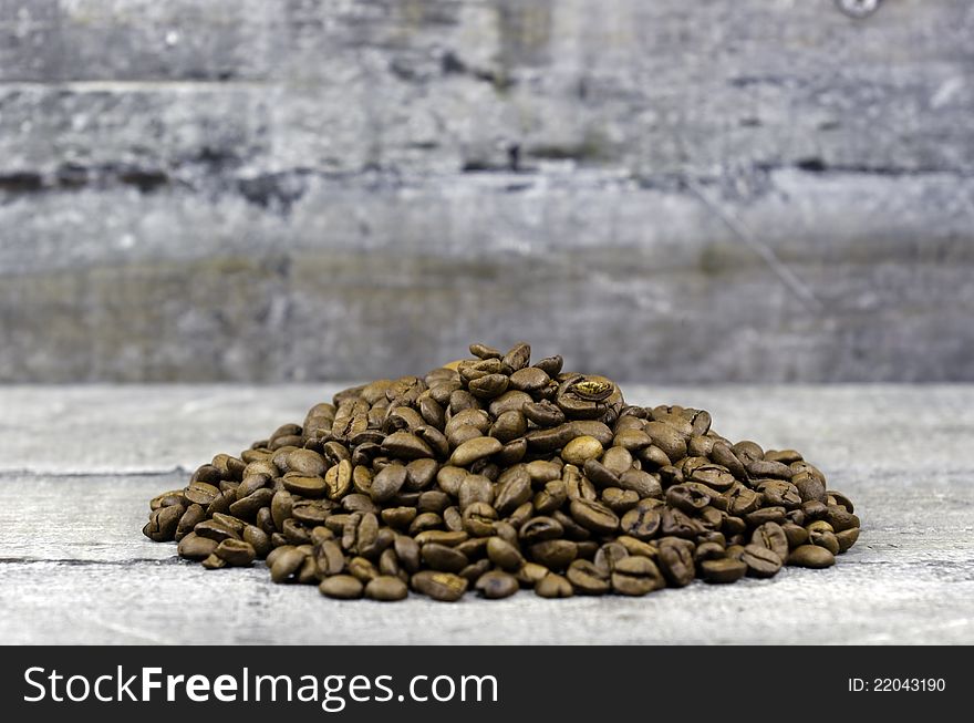 Coffee beans in bulk on wood background