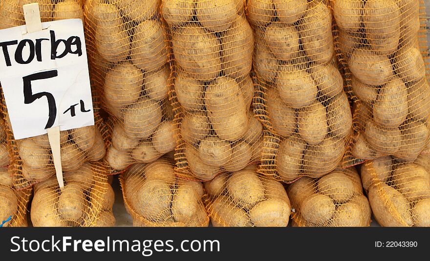 A view of some potato with bag in market.