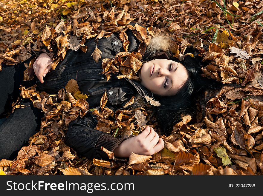 Woman lying in fallen leaves