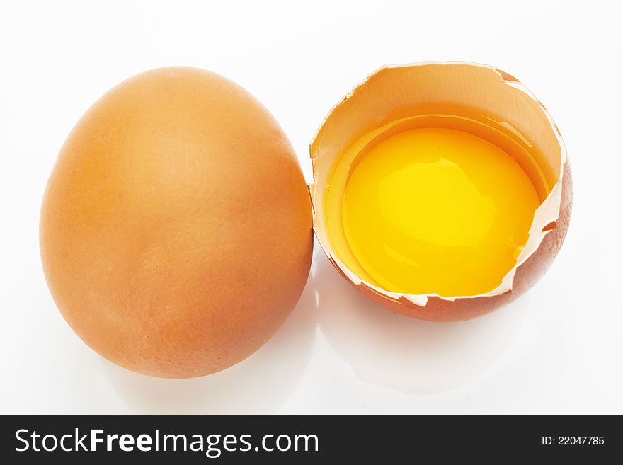 Two brown eggs on a white background. One egg is broken.