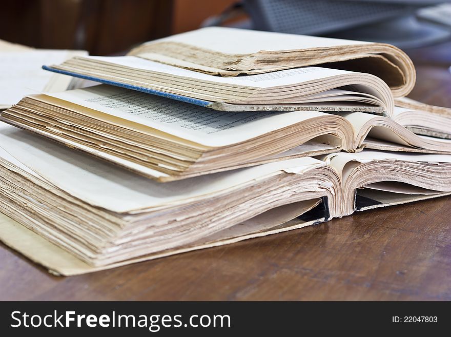 Stack of old books on wooden table