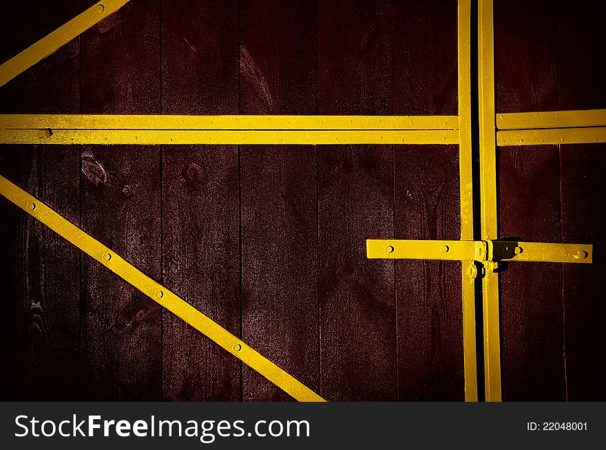 Wooden brown gate, with an yellow iron frame. Wooden brown gate, with an yellow iron frame