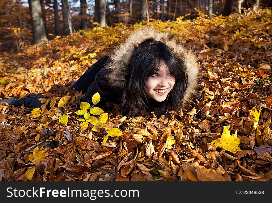 Young woman lying in fallen autumn leaves. Young woman lying in fallen autumn leaves