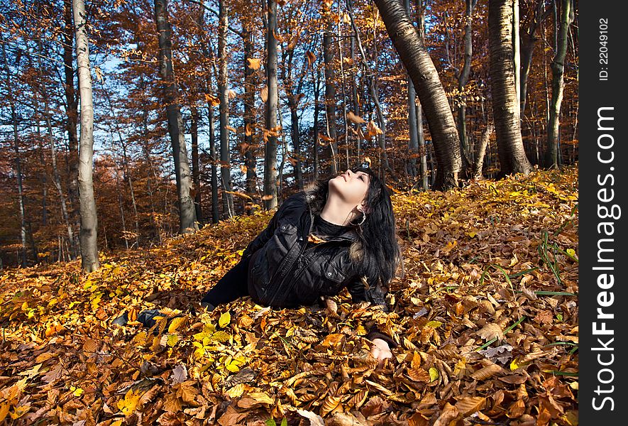 Young woman lying in fallen autumn leaves. Young woman lying in fallen autumn leaves