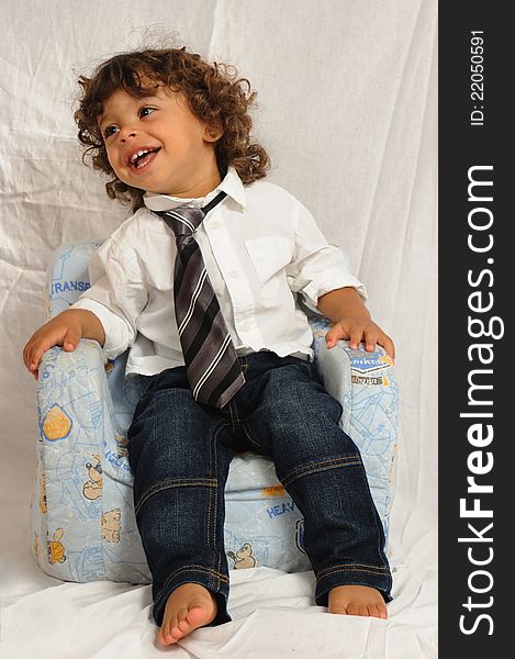 Baby sitting on a chair with necktie. Baby sitting on a chair with necktie