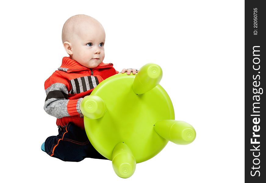 Little boy with a plastic chair in the studio on a white background