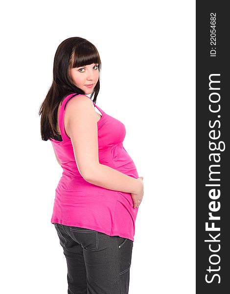 Pretty black-haired pregnant woman wearing bright pink dress holding her belly. Pretty black-haired pregnant woman wearing bright pink dress holding her belly