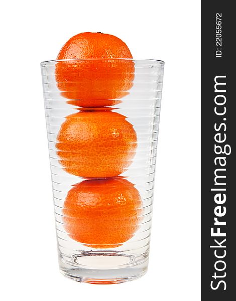 Three mandarin fruits stacked in glass.