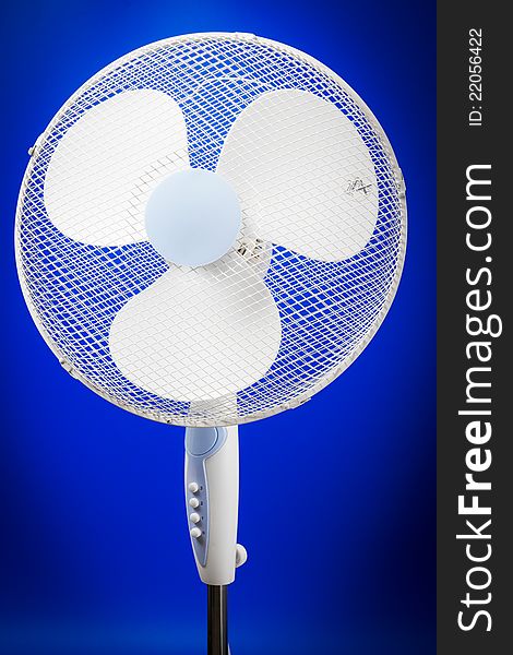 Electric fan on blue background