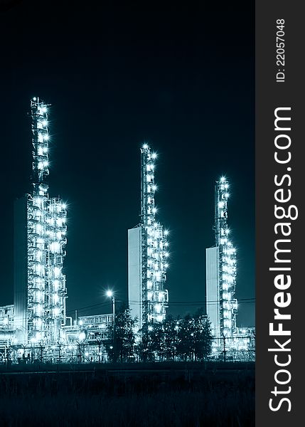 A brightly lit industrial site at night. Toned. A brightly lit industrial site at night. Toned.