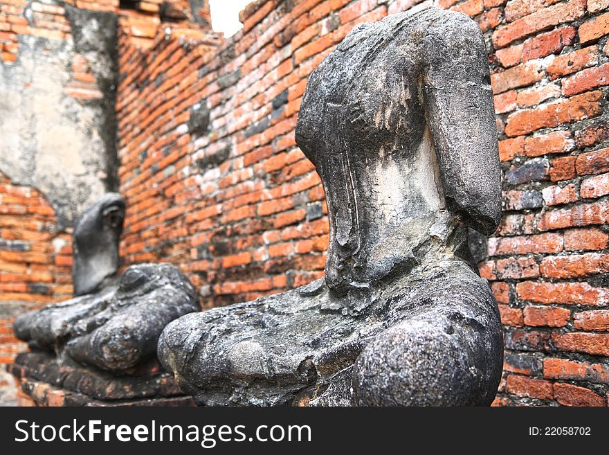Headless and armless Buddha images sitting inside a ruined temple in Ayutthaya, Thailand