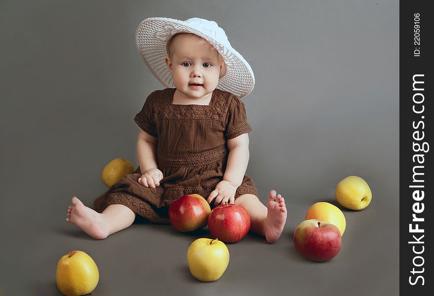Portrait of the child on a gray background with apples. Portrait of the child on a gray background with apples