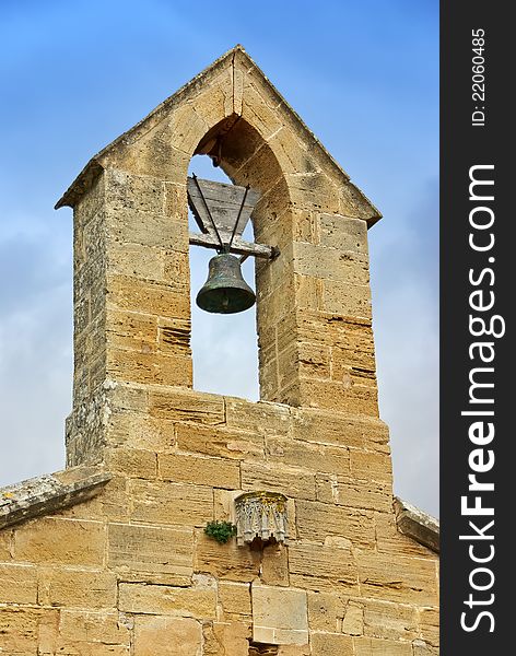 Bell tower over an ancient spanish church