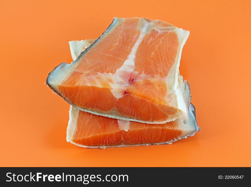 Closeup photo of fresh raw salmon on an orange background