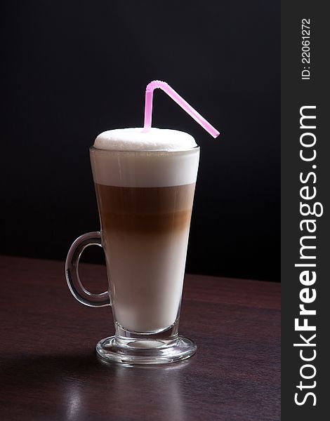 Latte glass with foam and straw