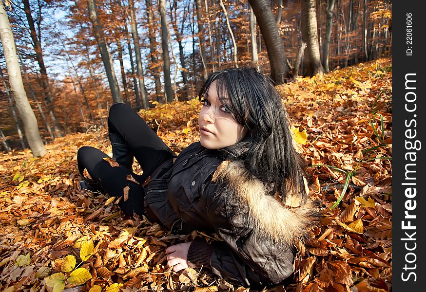 Woman lying in fallen leaves