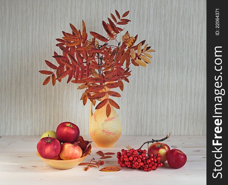 The vase with leaves of a mountain ash costs on desktop and also apples and berries of a mountain ash. The vase with leaves of a mountain ash costs on desktop and also apples and berries of a mountain ash.