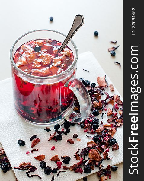 Hot vitamin drink from dried fruits and berries in a transparent cup.