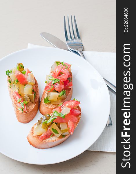 Three delicious toast with vegetables on a white plate.