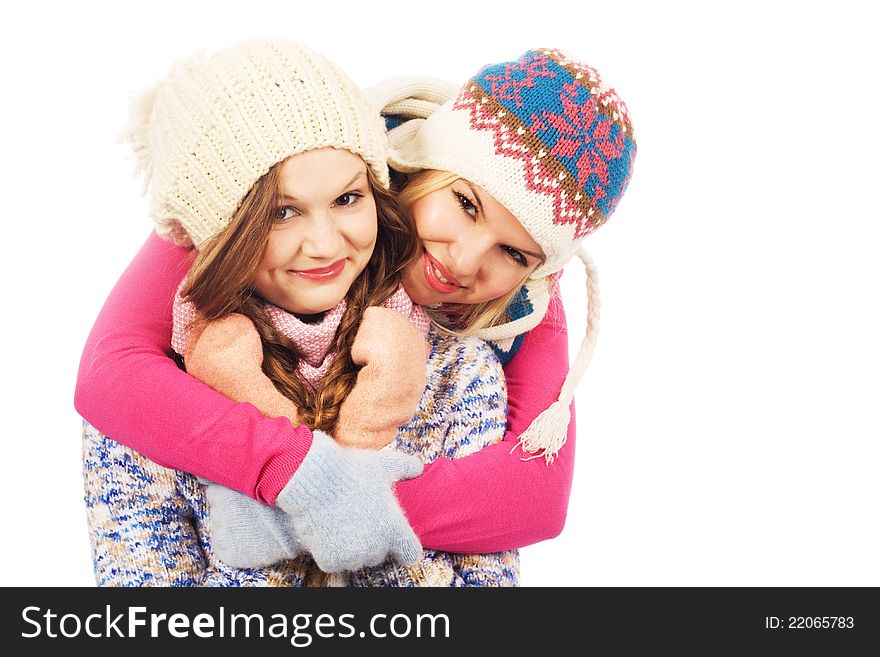 Two lovely girlfriends in winter clothing against white background