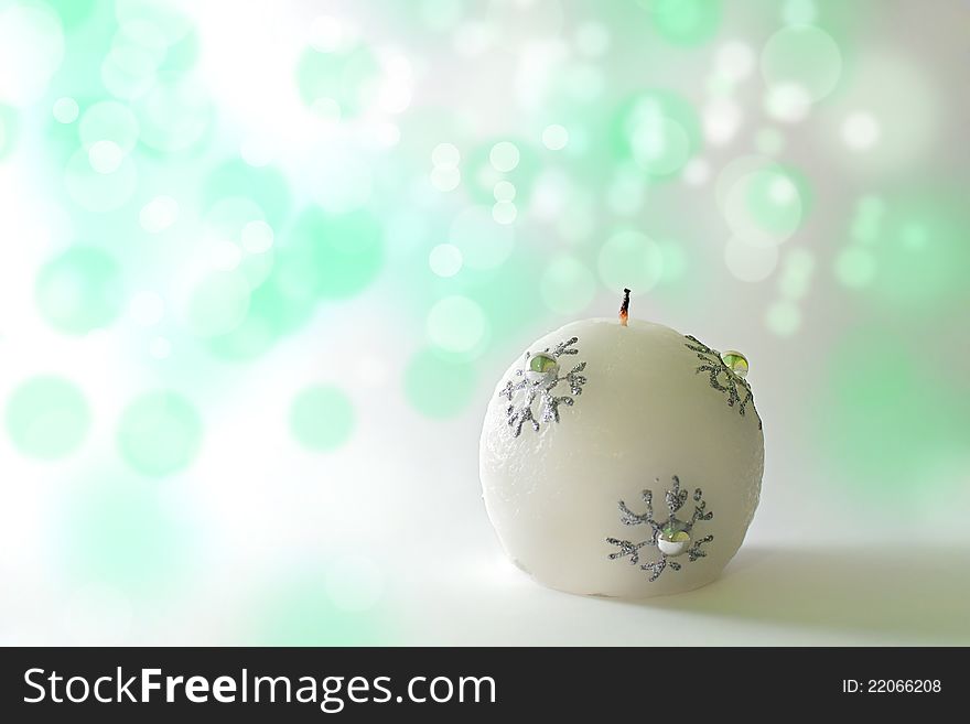 Christmas candle on a green bokeh background. Christmas candle on a green bokeh background