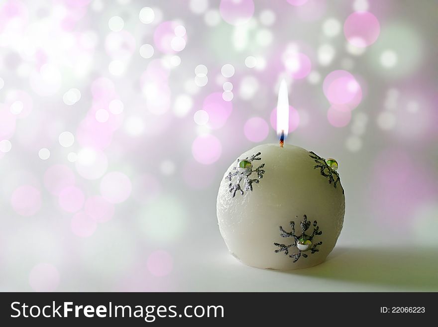 Lit christmas candle on an elegant bokeh background. Lit christmas candle on an elegant bokeh background