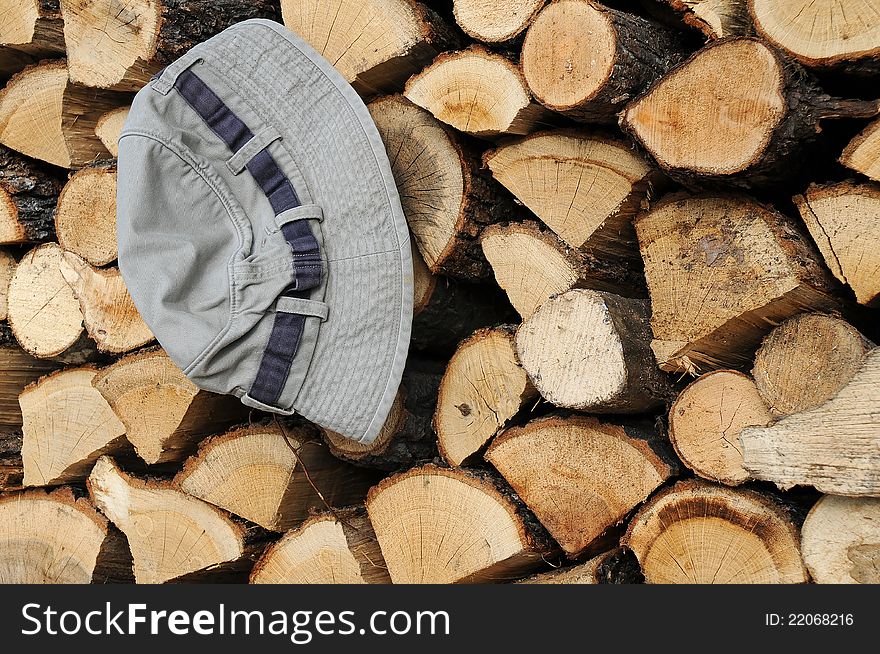 Stack of firewood and a hat. Stack of firewood and a hat
