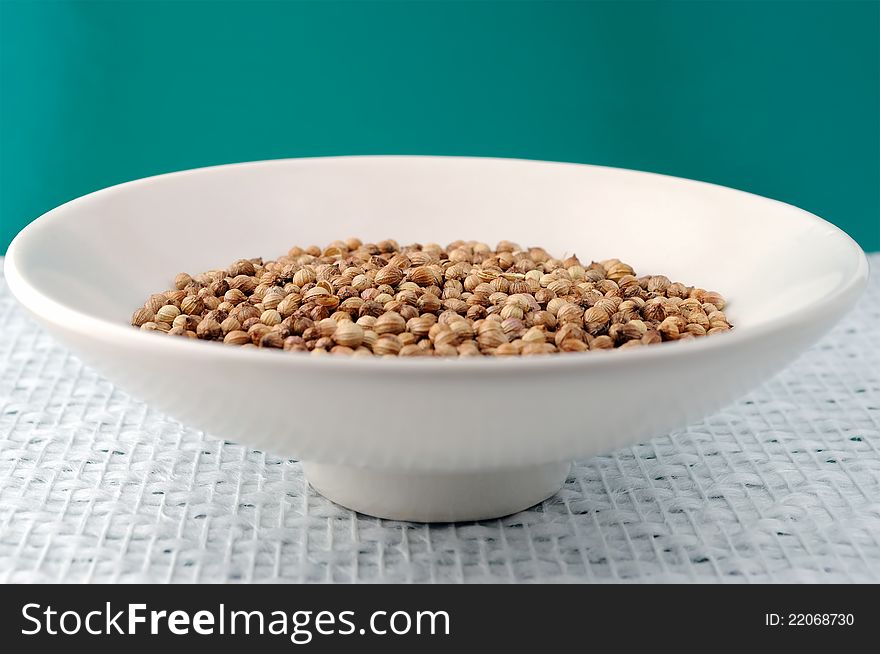 A handful of coriander seeds on a bowl