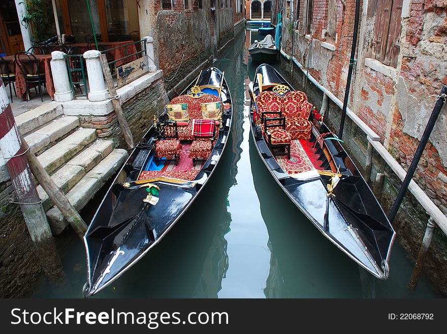 A pair of gondolas moored on a quiet canal in Venice. A pair of gondolas moored on a quiet canal in Venice.