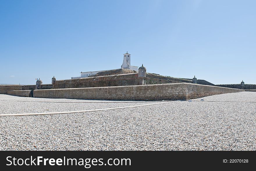 This is a fortress of Peniche, decorated with a garden of small white stones around it.