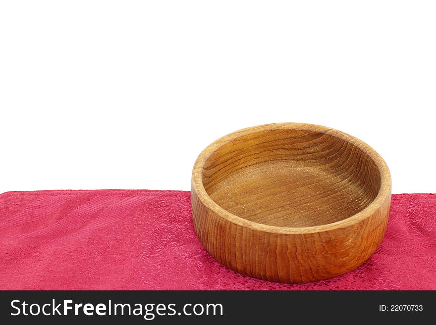 Empty teak wood bowl on a red placemat isolated on a white background. Empty teak wood bowl on a red placemat isolated on a white background.