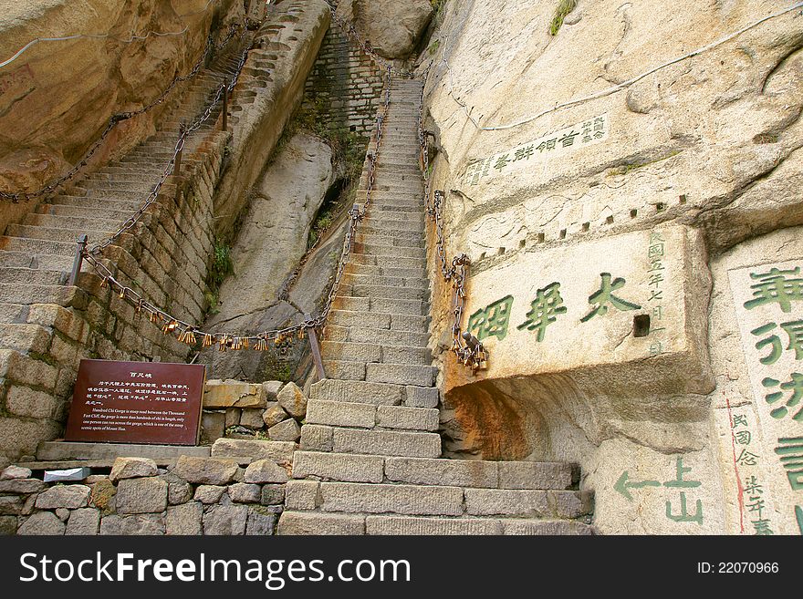 Mountain climbing dangerous road in Mount Hua(Huashan). The words on rock are carved by ancient people. Huashan is one of the most perilous tourist attractions in china. Huashan is located in Huayin, Shaanxi, China. Mountain climbing dangerous road in Mount Hua(Huashan). The words on rock are carved by ancient people. Huashan is one of the most perilous tourist attractions in china. Huashan is located in Huayin, Shaanxi, China.