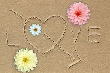 Love Word With Love Sign And Flowers On Sand Stock Photos