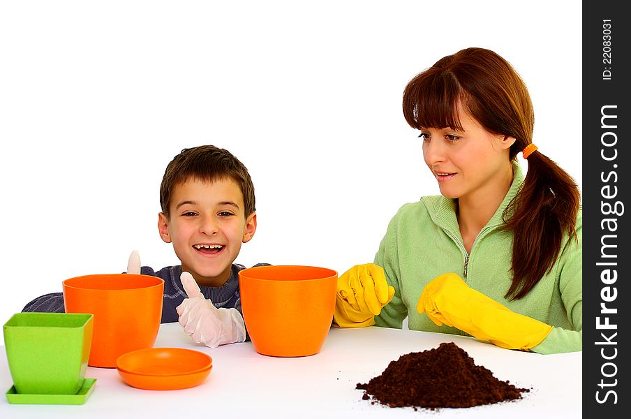 Mother and her son (boy, kid) ready to plant flowers isolated on a white background with different color flowerpots. Mother and her son (boy, kid) ready to plant flowers isolated on a white background with different color flowerpots