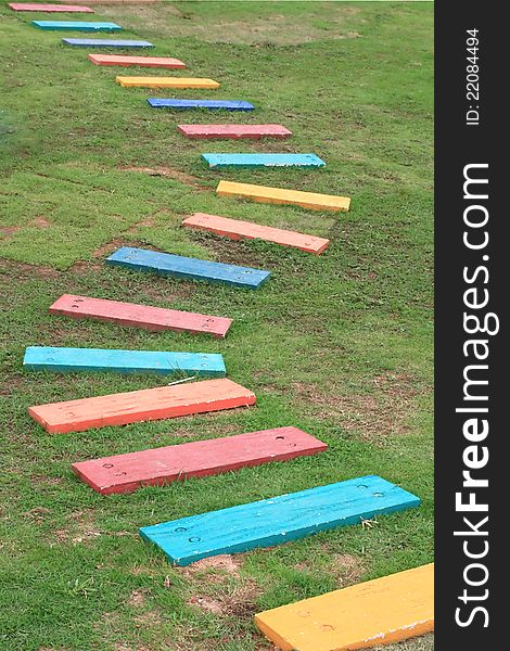 Colorful Wooden Walkway and Pathway in the Green garden grass fields