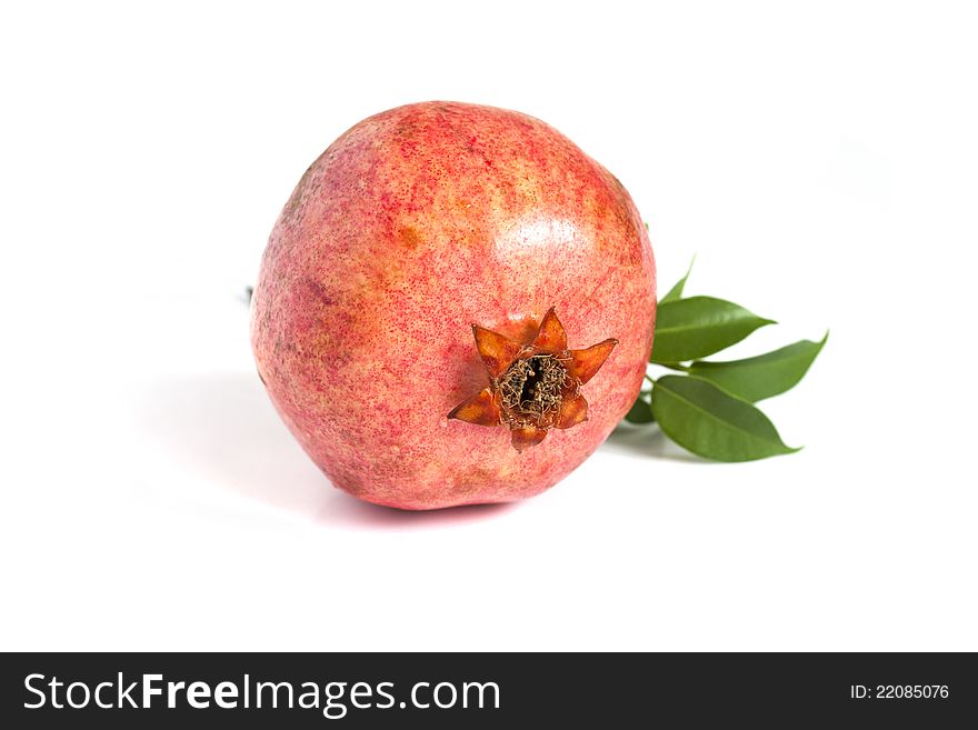 Juicy pomegranate with leaves on white
