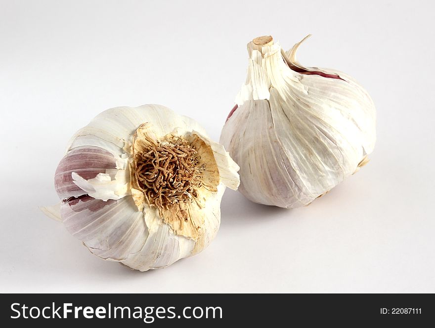 Two garlic bulbs on a white background. Two garlic bulbs on a white background.