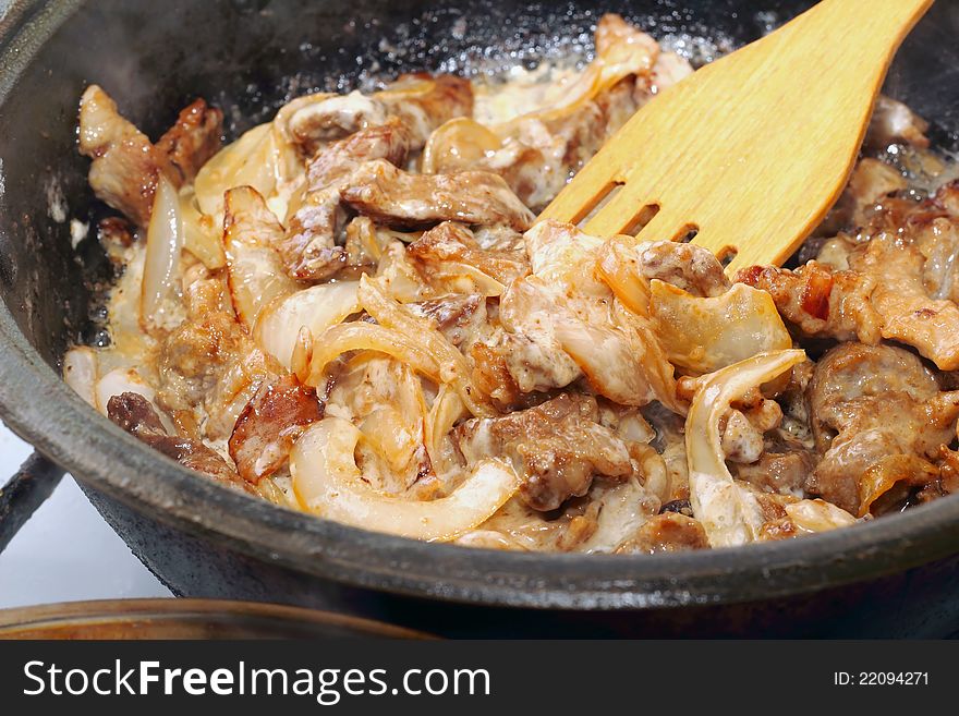 Meat fried with sour cream on a frying pan. Meat fried with sour cream on a frying pan