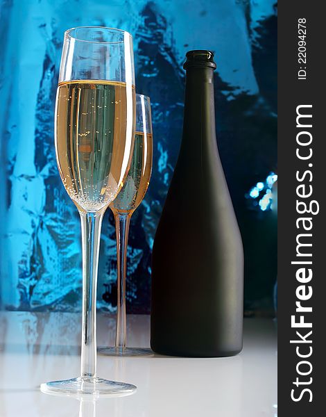 Glass of champagne and bottle.Blue background