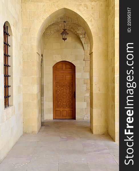 An arched entrance in a Lebanese palace with a carved wooden door. An arched entrance in a Lebanese palace with a carved wooden door