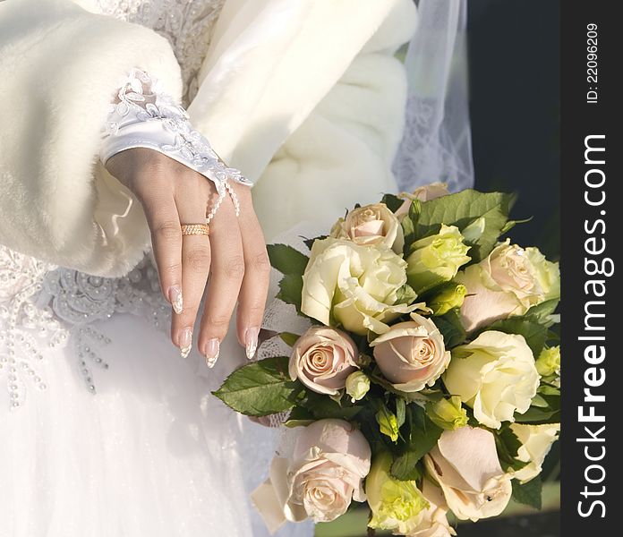 Hand of fiancee with a wedding ring a bouquet from roses. Hand of fiancee with a wedding ring a bouquet from roses