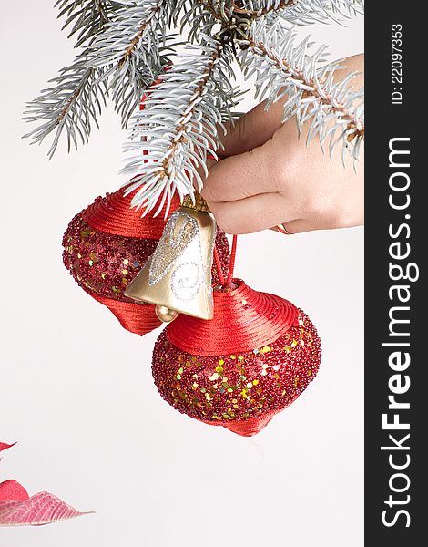 Human hand hanging christmas ornaments