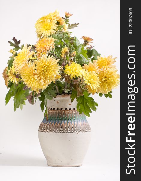Yellow fall flowers decorating traditional vase
