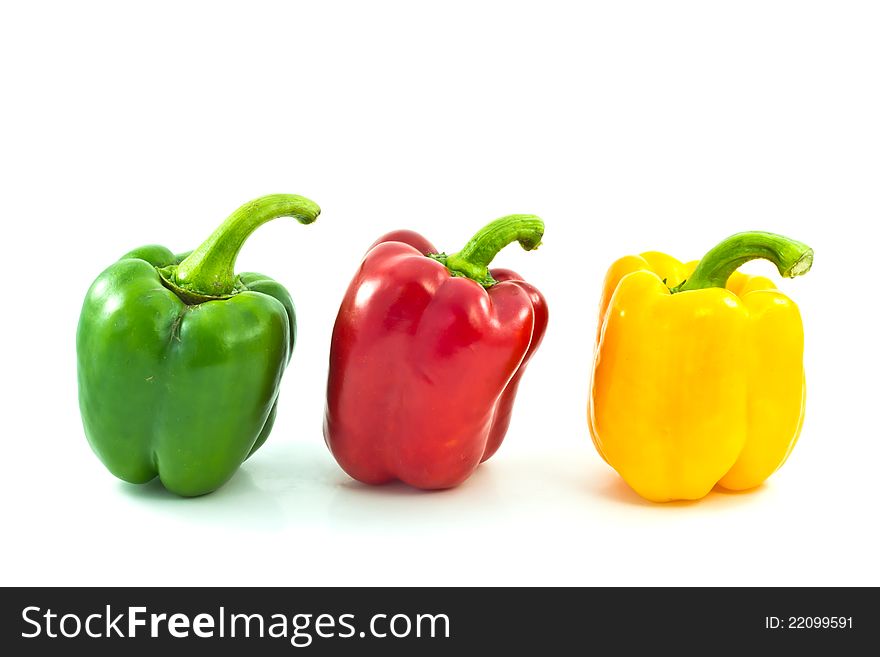 Red, yellow and green bell peppers on the white backgro