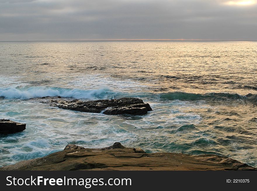 Rocks at Shore San Diego California Beach wit sun setting down